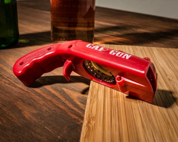 Bottle opener with cap gun