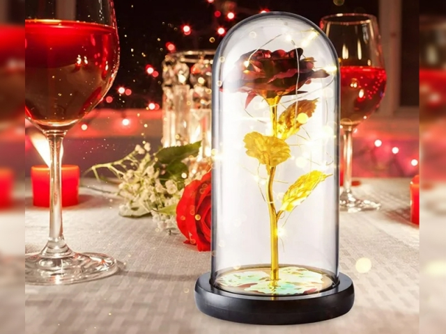 Večná červená a zlatá ruža v skle so svetlom