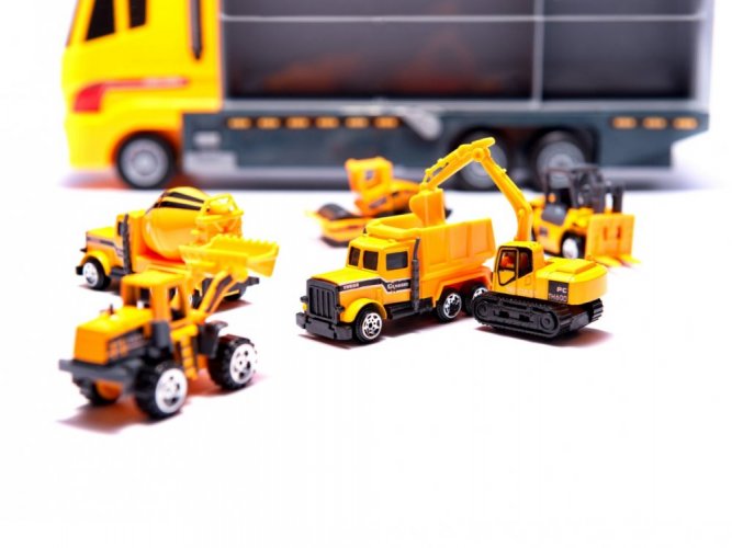 A truck with six metal cars with construction equipment